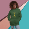 Smiling woman in green hoodie with 'LOVE is the G.O.A.T.' text.