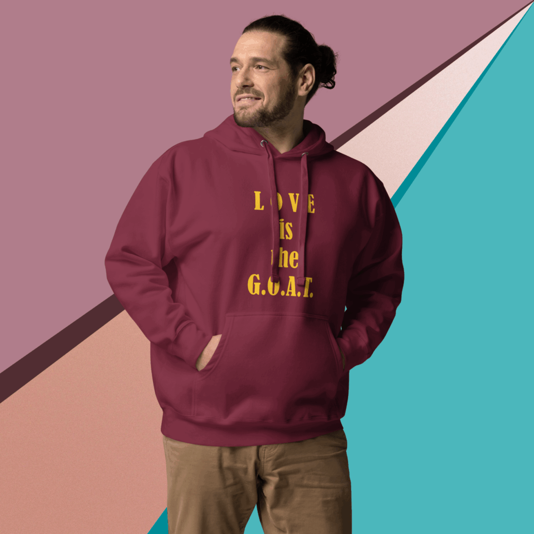 Man wearing a maroon hoodie with text, standing in front of a colorful geometric background.