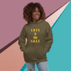 Smiling woman wearing an olive green hoodie with "LOVE is the G.O.A.T." text.
