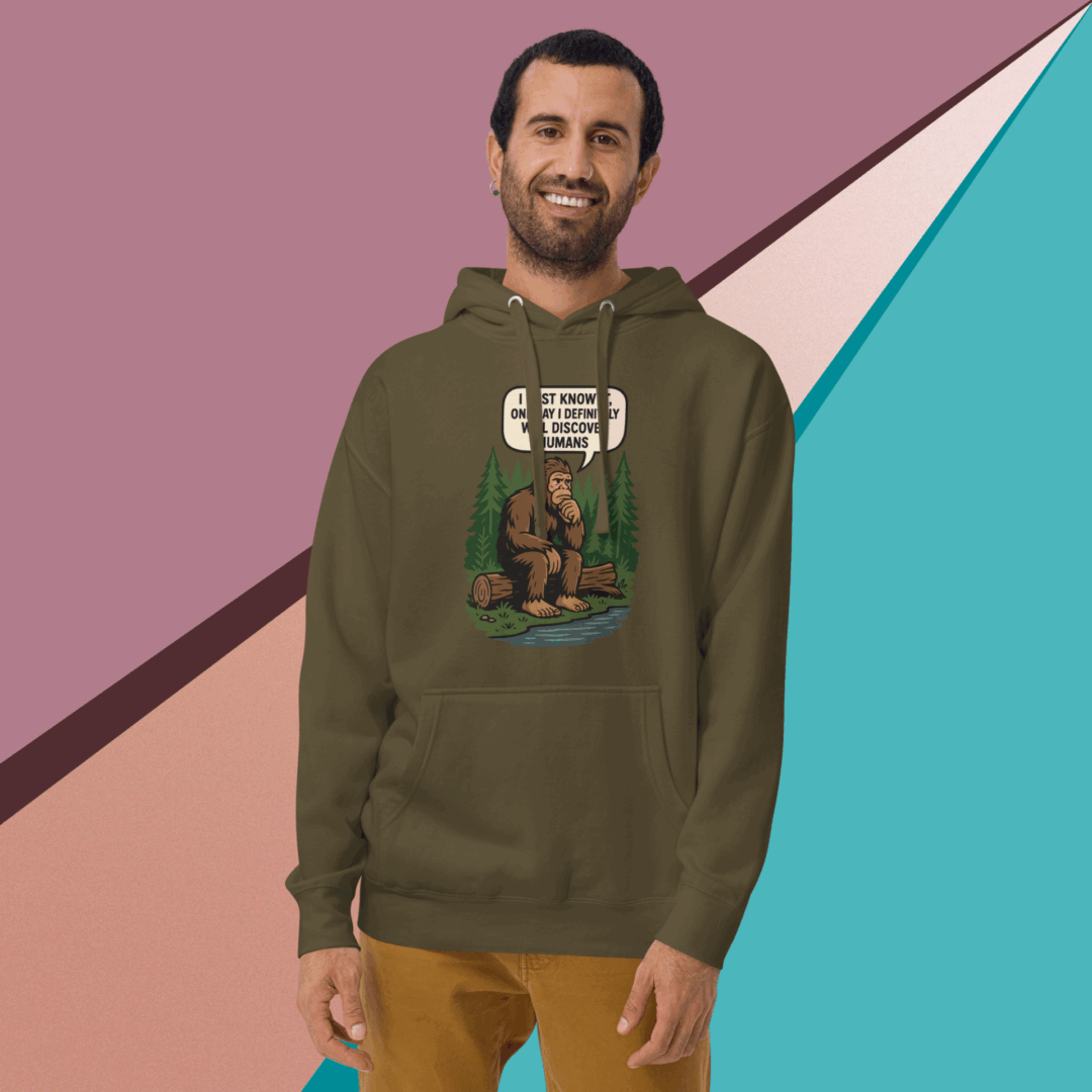 Smiling man wearing a graphic hoodie with brown pants.