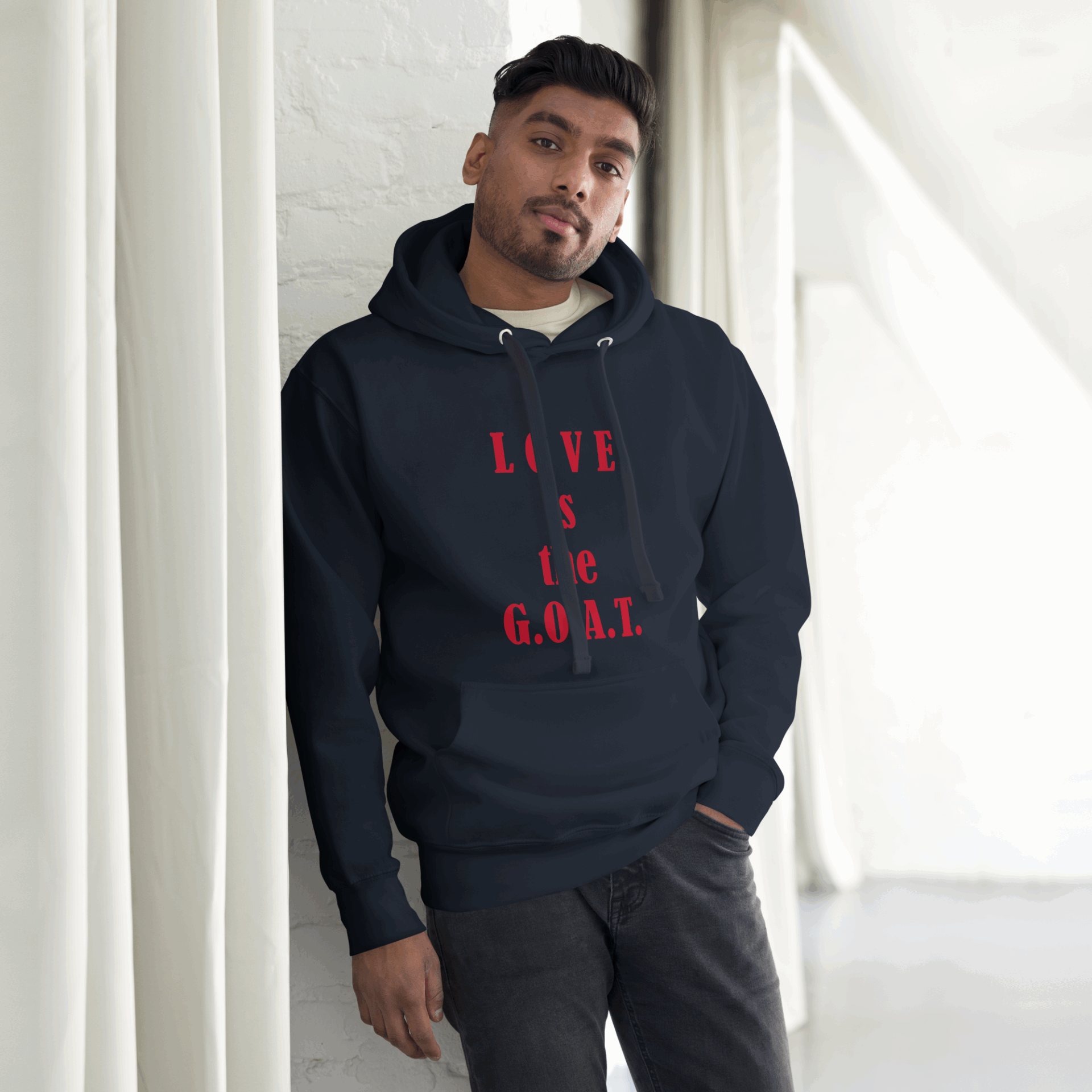 Man wearing a black hoodie with 'LOVE IS THE GOAL' printed in red.