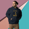 Man wearing a navy hoodie with gold text on a colorful geometric background.