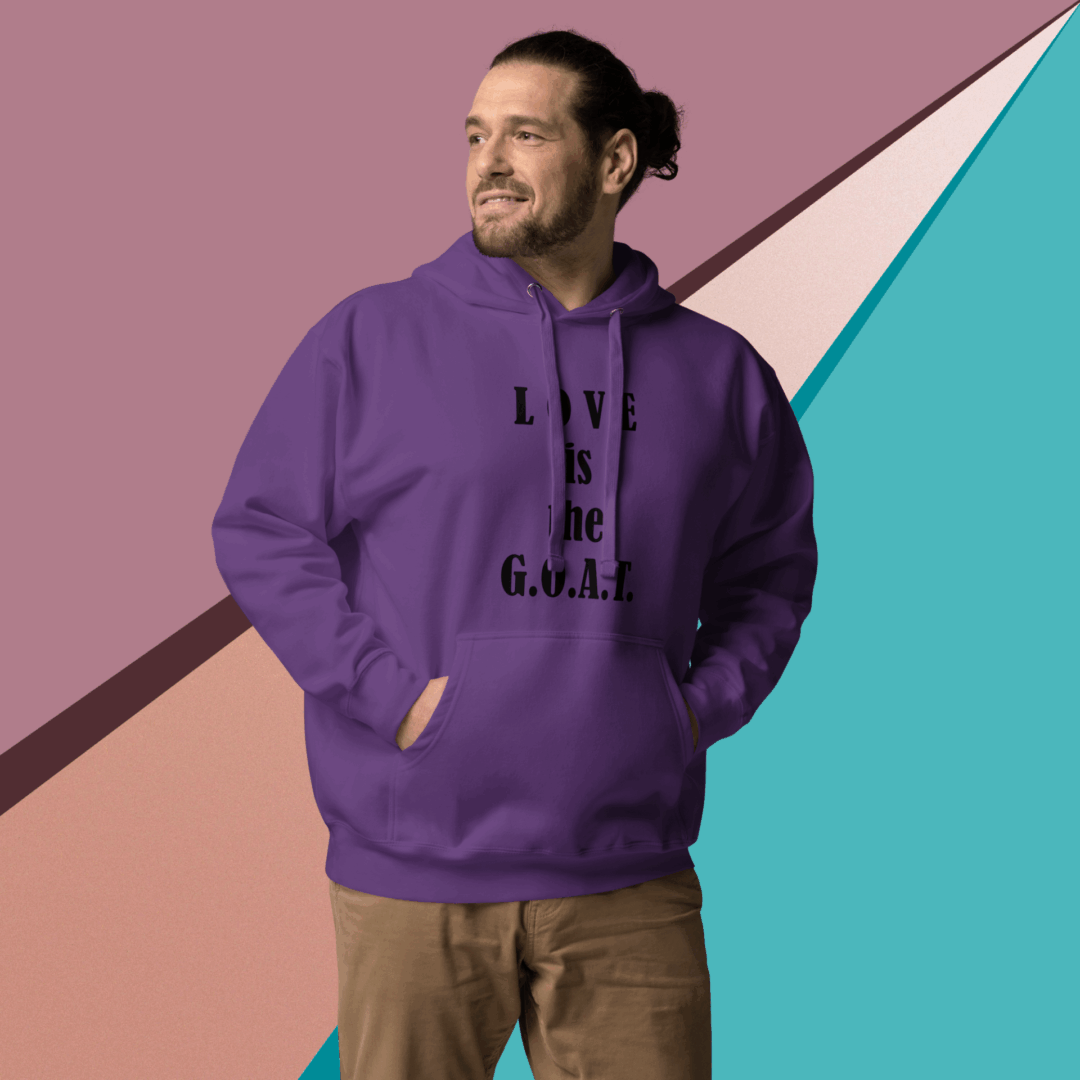 Man in a purple hoodie smiling against a colorful geometric wall.