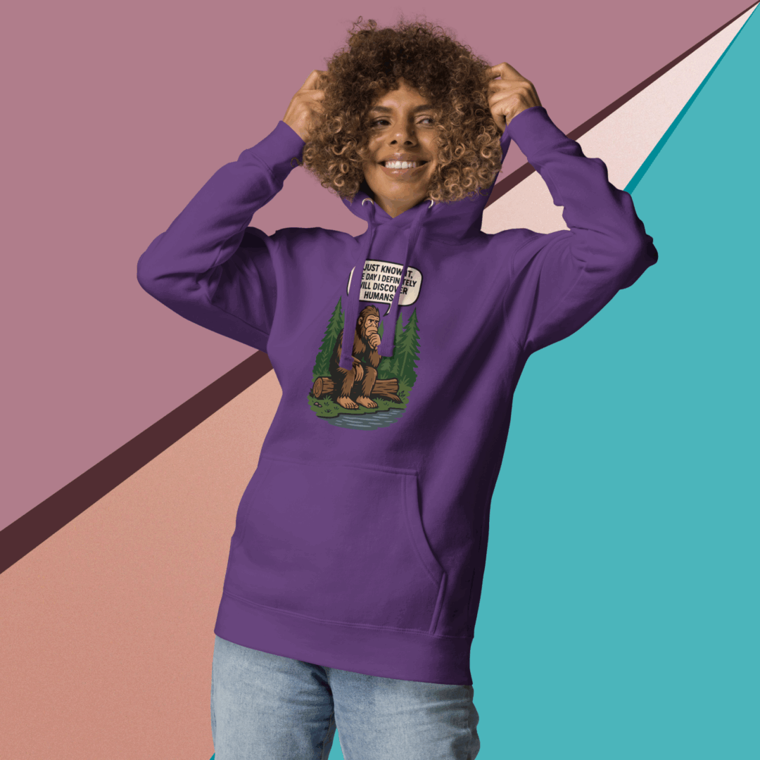 Person wearing a purple hoodie with a graphic design, smiling and posing against a colorful background.