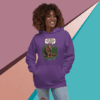 A woman smiling wearing a purple hoodie with a colorful graphic design.