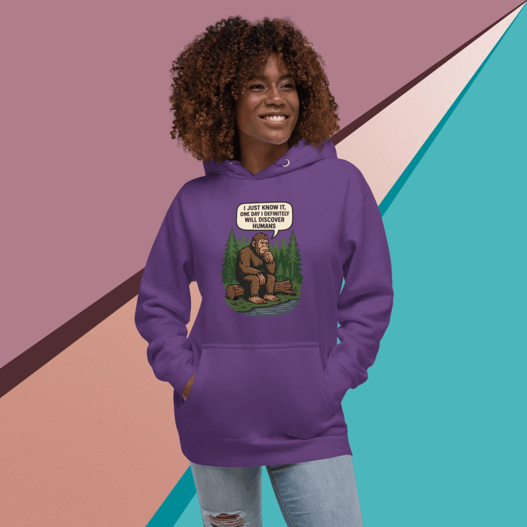 A woman smiling wearing a purple hoodie with a colorful graphic design.
