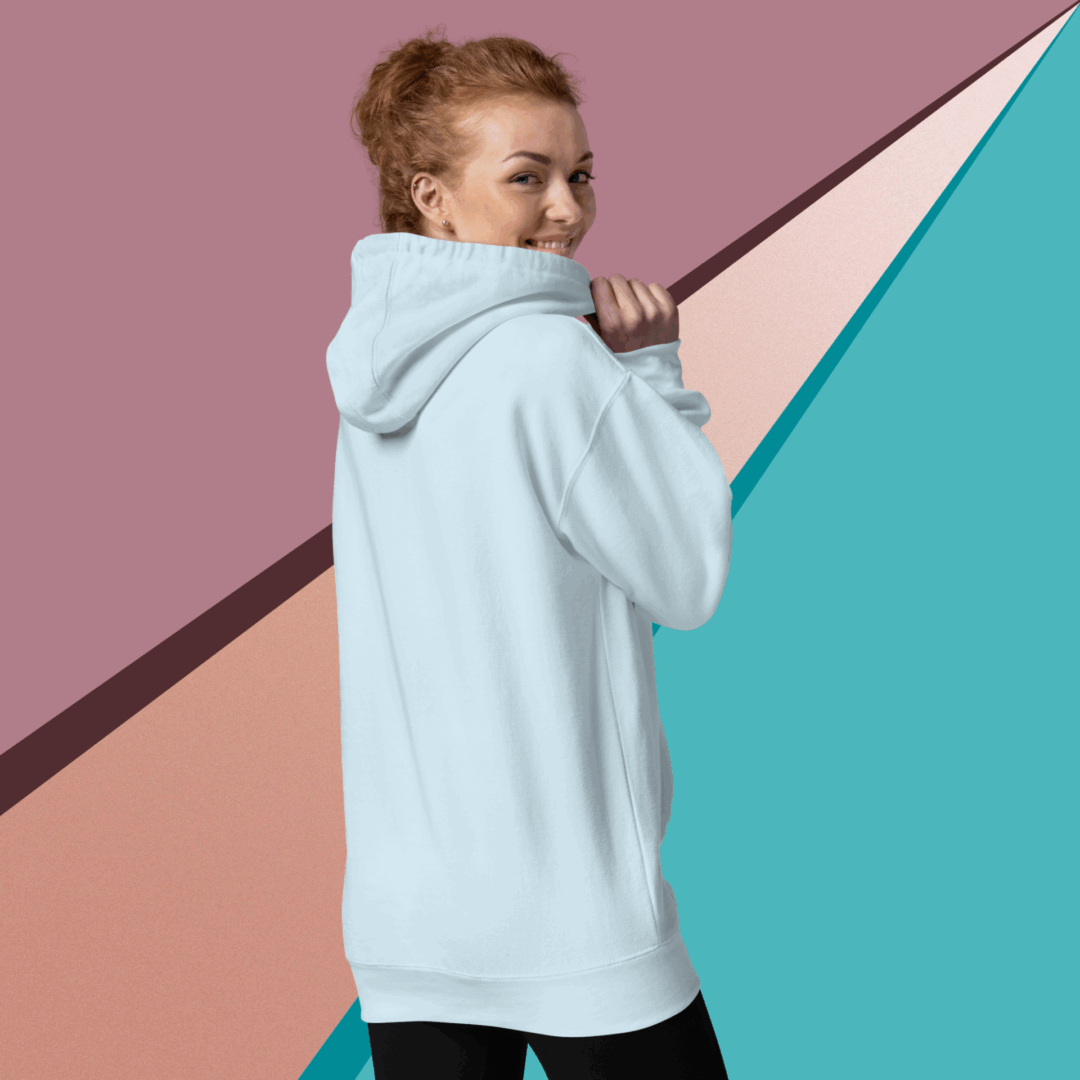 cotton-heritage-m2580-i-unisex-premium-pullover-hoodie-sky-blue-back-68f046de07ce1 Smiling woman in a cozy light blue hoodie against a colorful geometric background.