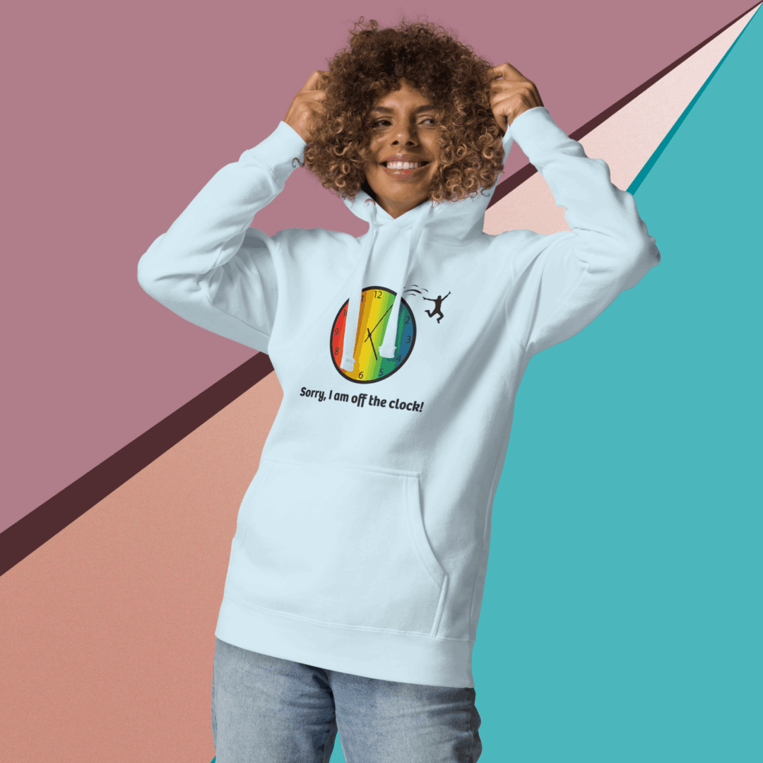 cotton-heritage-m2580-i-unisex-premium-pullover-hoodie-sky-blue-front-68e325432bc86 Smiling woman wearing a light blue hoodie with a colorful logo.