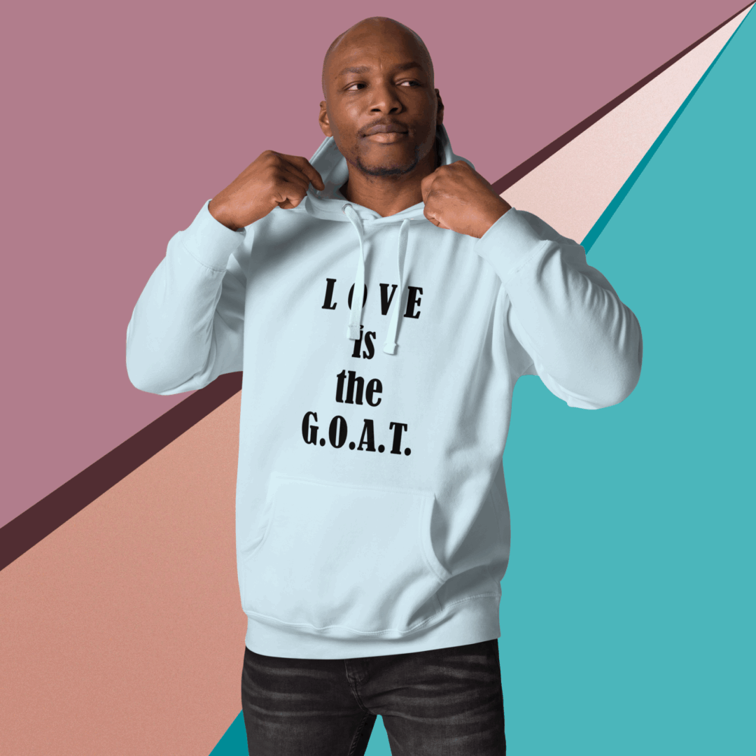 Man wearing a light blue hoodie with the text 'LOVE is the G.O.A.T.'