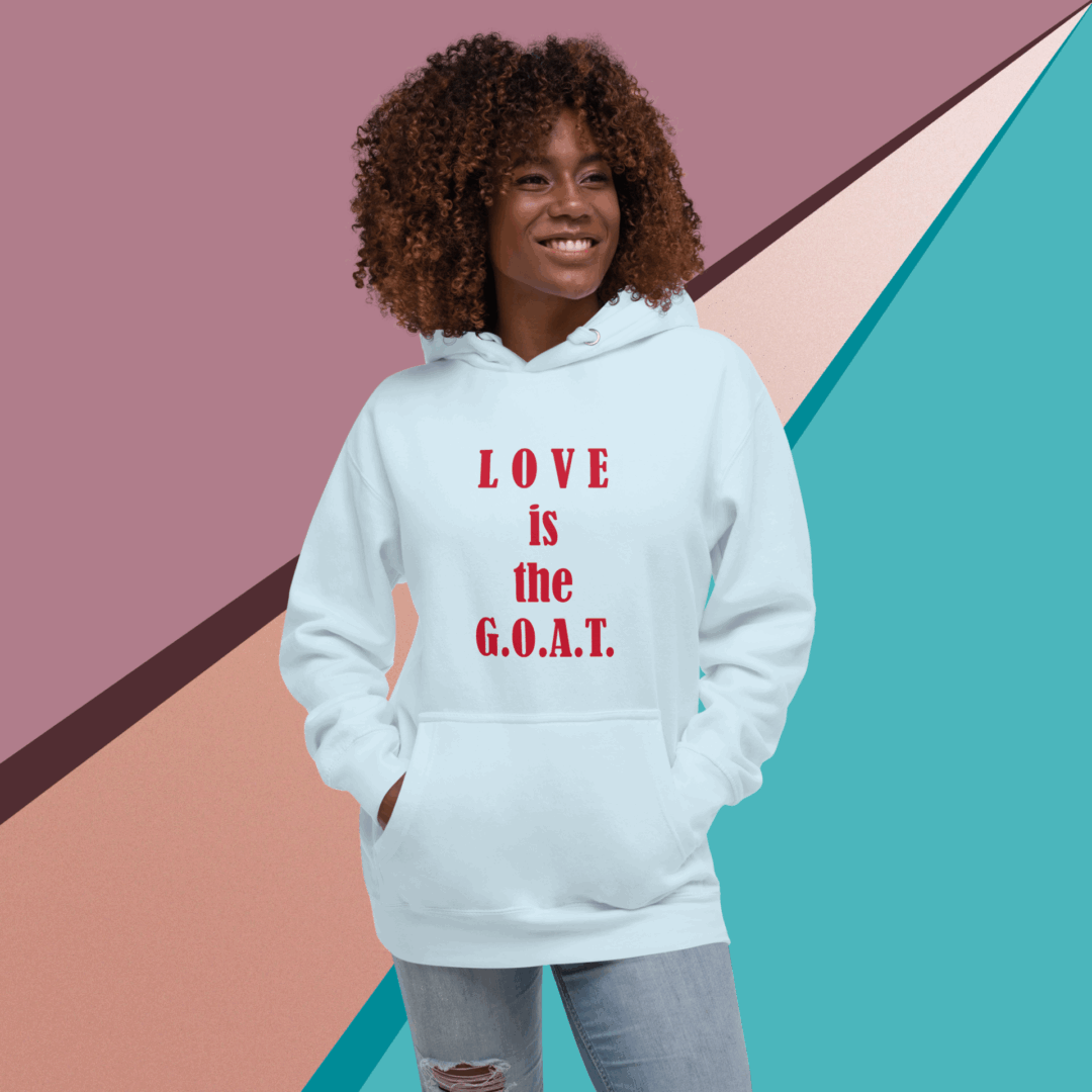 Woman smiling, wearing a white hoodie with 'LOVE is the G.O.A.T.' text.