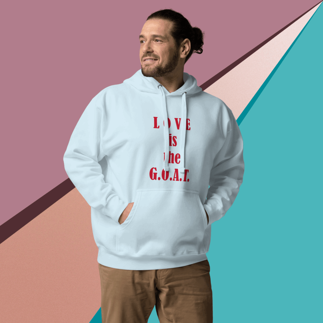 Man smiling wearing a white hoodie with 'LOVE IS G.O.A.T.' text.