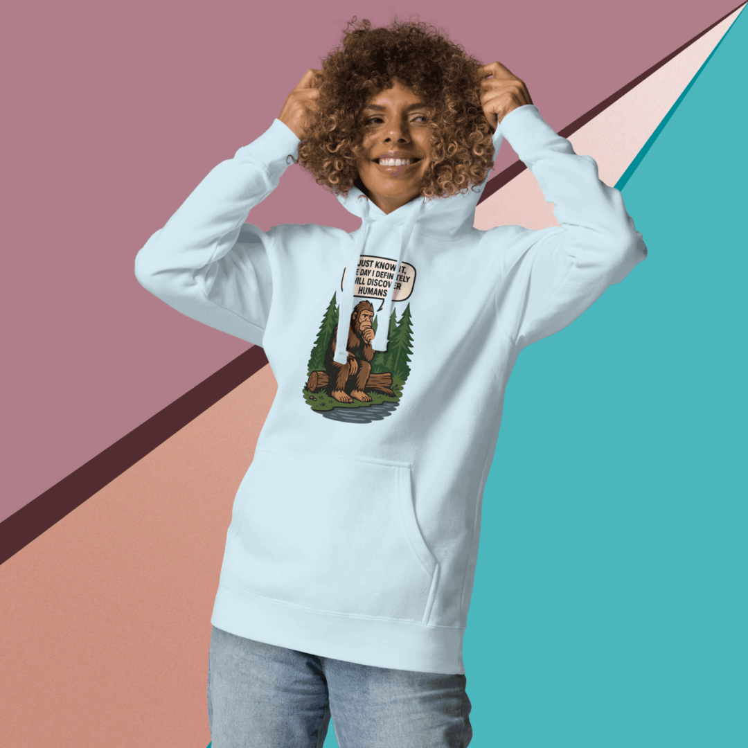 Smiling person wearing a hoodie with a colorful bear graphic.
