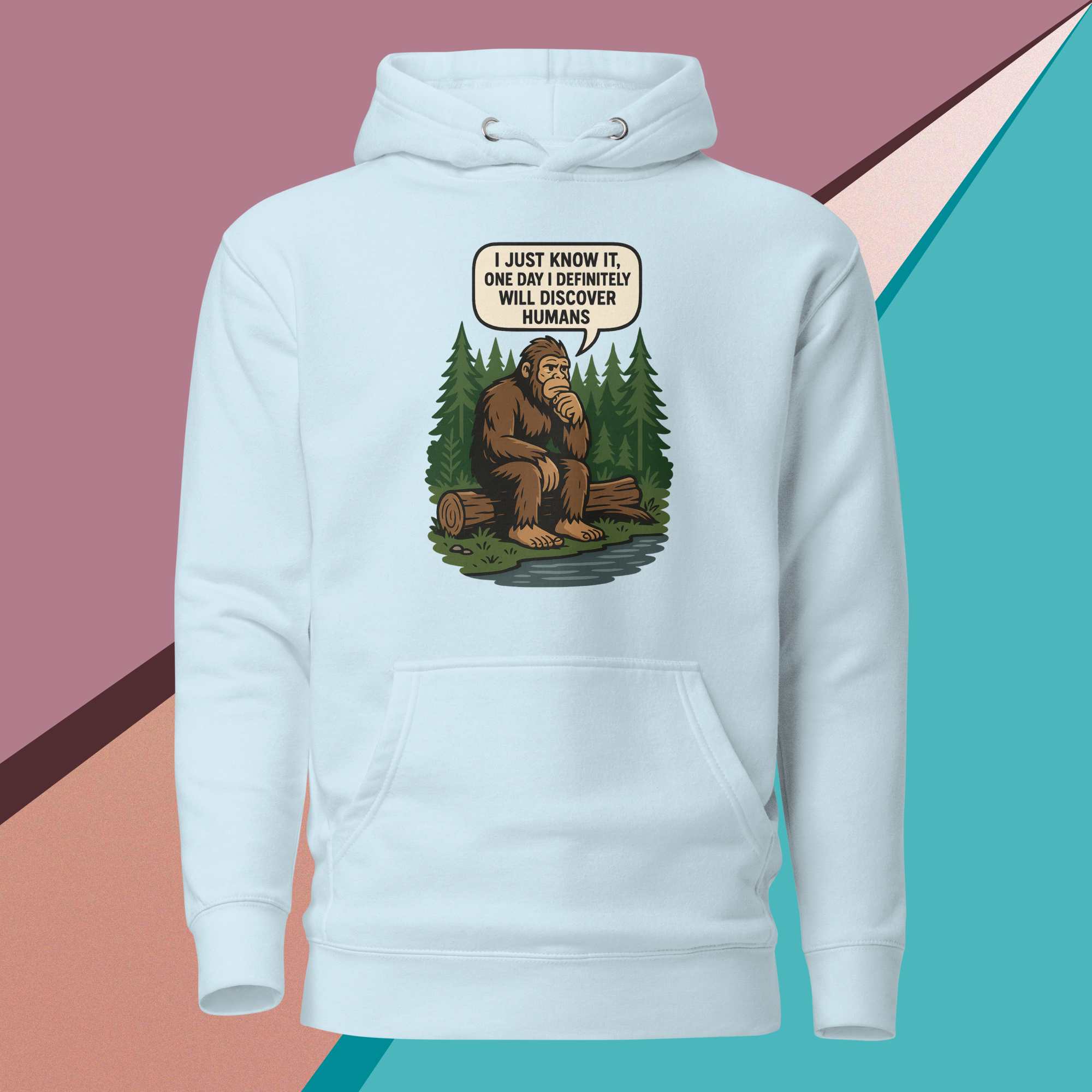 Light blue hoodie featuring a thoughtful Bigfoot cartoon with a humorous quote about discovering humans.