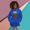 A smiling woman in a blue hoodie stands against a colorful geometric background.