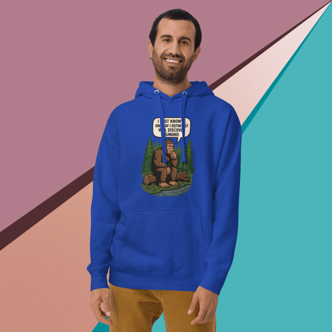 Man in a blue hoodie with a graphic design, smiling against a colorful geometric background.