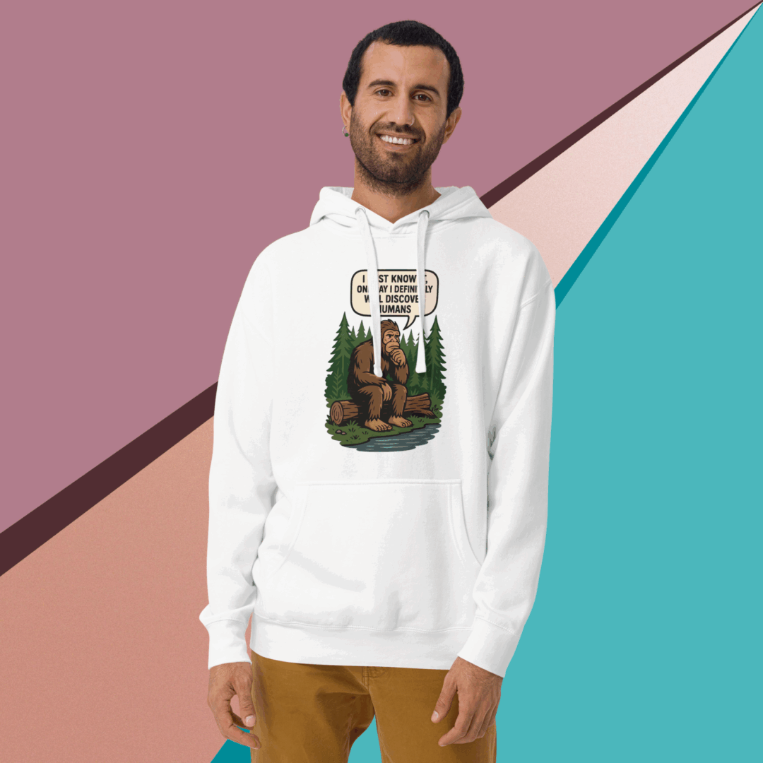 Man wearing a white hoodie with a colorful graphic design, smiling against a geometric background.
