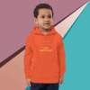 Young boy wearing an orange hoodie with text, standing against a colorful geometric background.