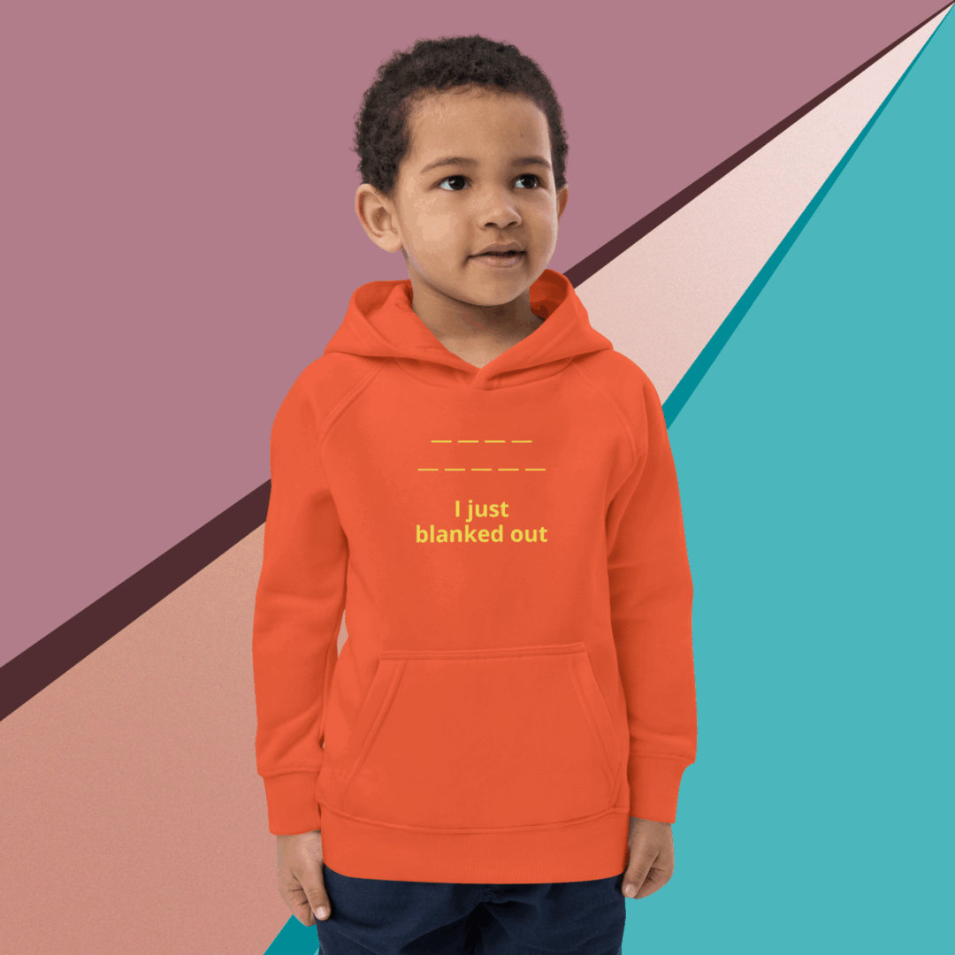 Young boy wearing an orange hoodie with text, standing against a colorful geometric background.