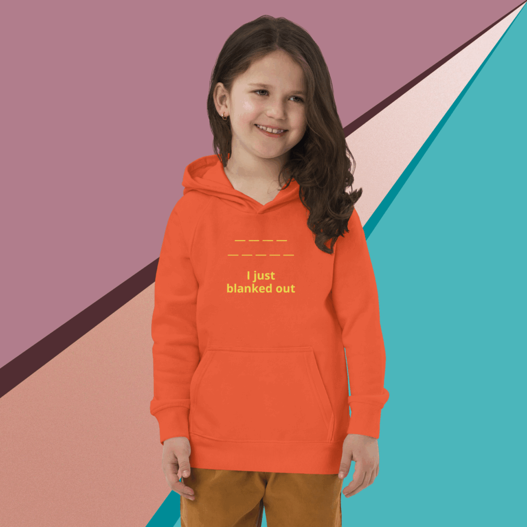 Smiling girl in orange hoodie holding a book against colorful geometric background.