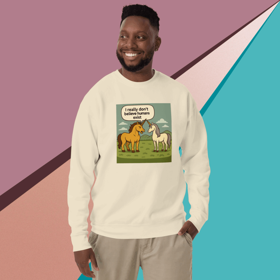 Smiling man wearing a cream sweatshirt with a cartoon dinosaur and text design.