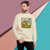 Man wearing a cream sweater with a cartoon camel and text design.