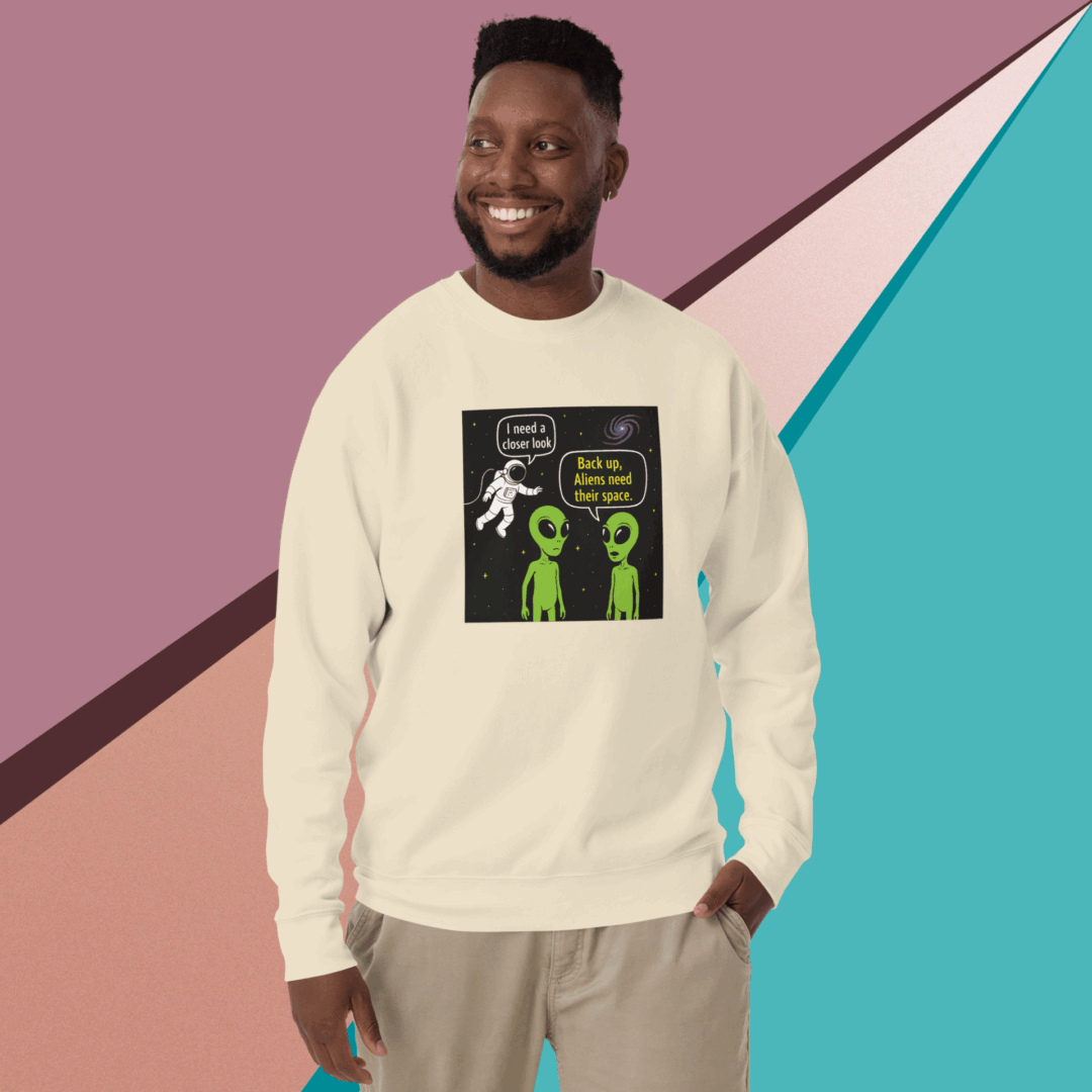 Smiling man in casual beige sweatshirt with a graphic design stands against a colorful geometric background.