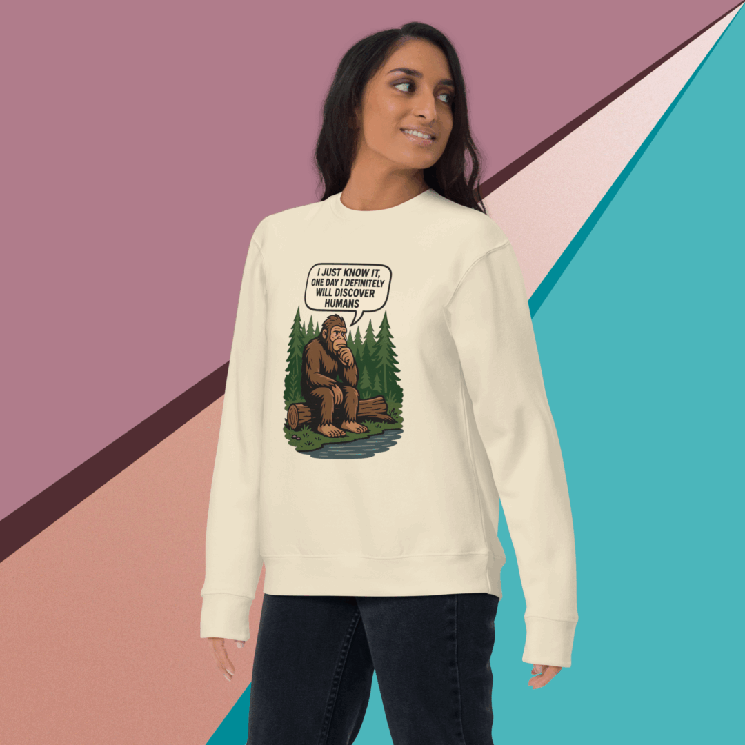 Woman wearing a white sweatshirt with a bear and forest graphic design.