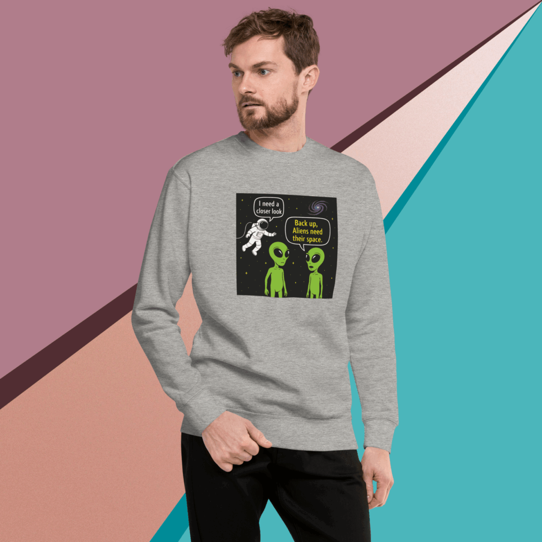 Man wearing grey sweatshirt with humorous alien graphic print.