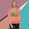 Woman wearing a coral sweatshirt with a colorful dinosaur graphic design.