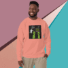 A man smiles wearing a peach sweatshirt with a science-themed graphic against a colorful geometric background.