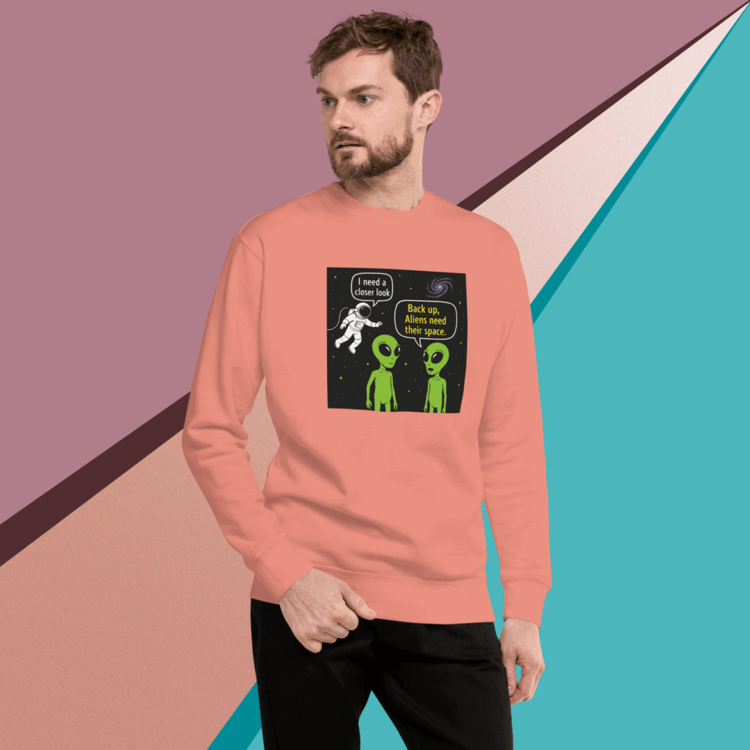 Man wearing a peach sweatshirt with a colorful graphic design on the front.