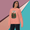Woman wearing a pink sweatshirt with a mountain and forest graphic design.