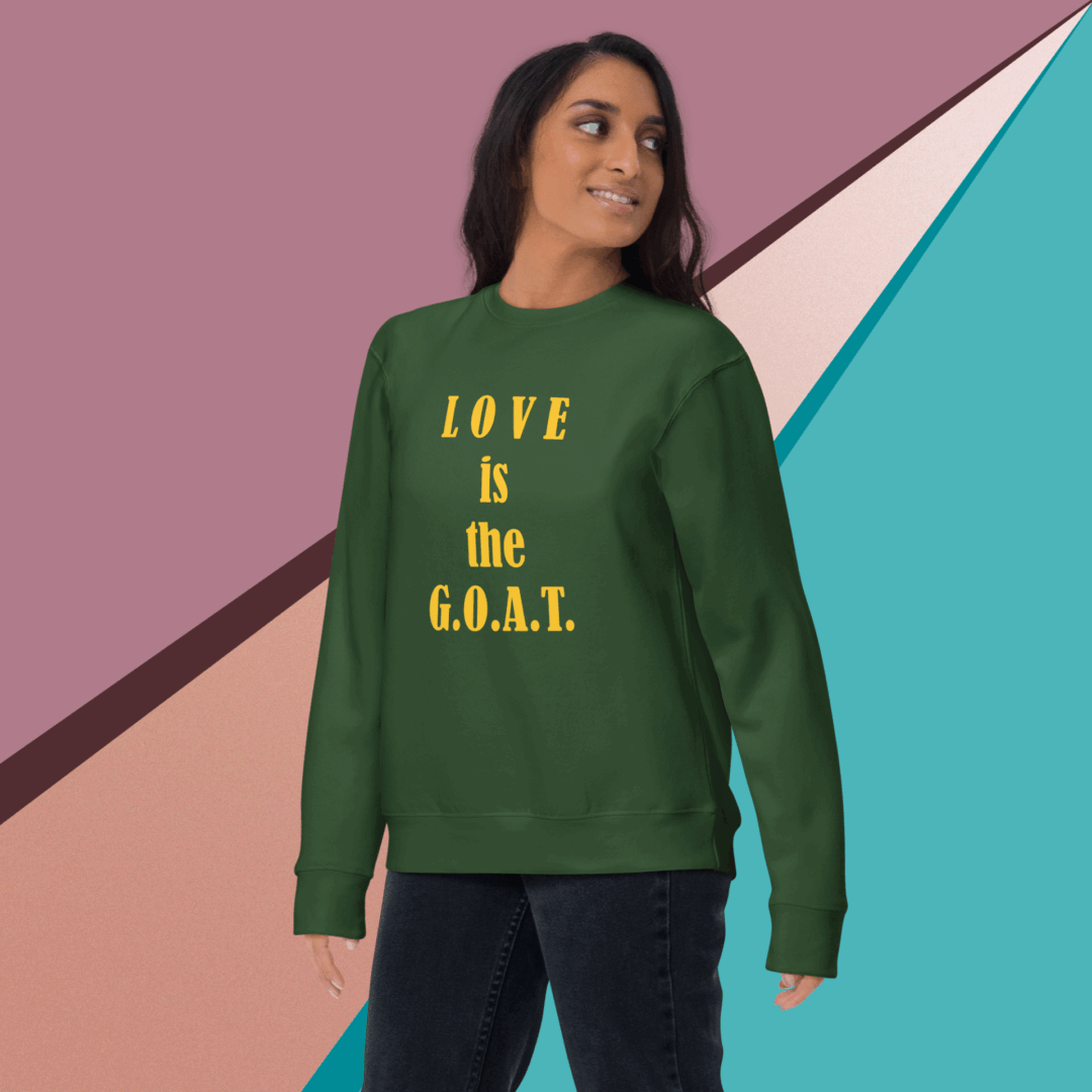 unisex-premium-sweatshirt-forest-green-front-68f061abc63e6 A woman wearing a green sweatshirt with 'LOVE IS the G.O.A.T.' text.