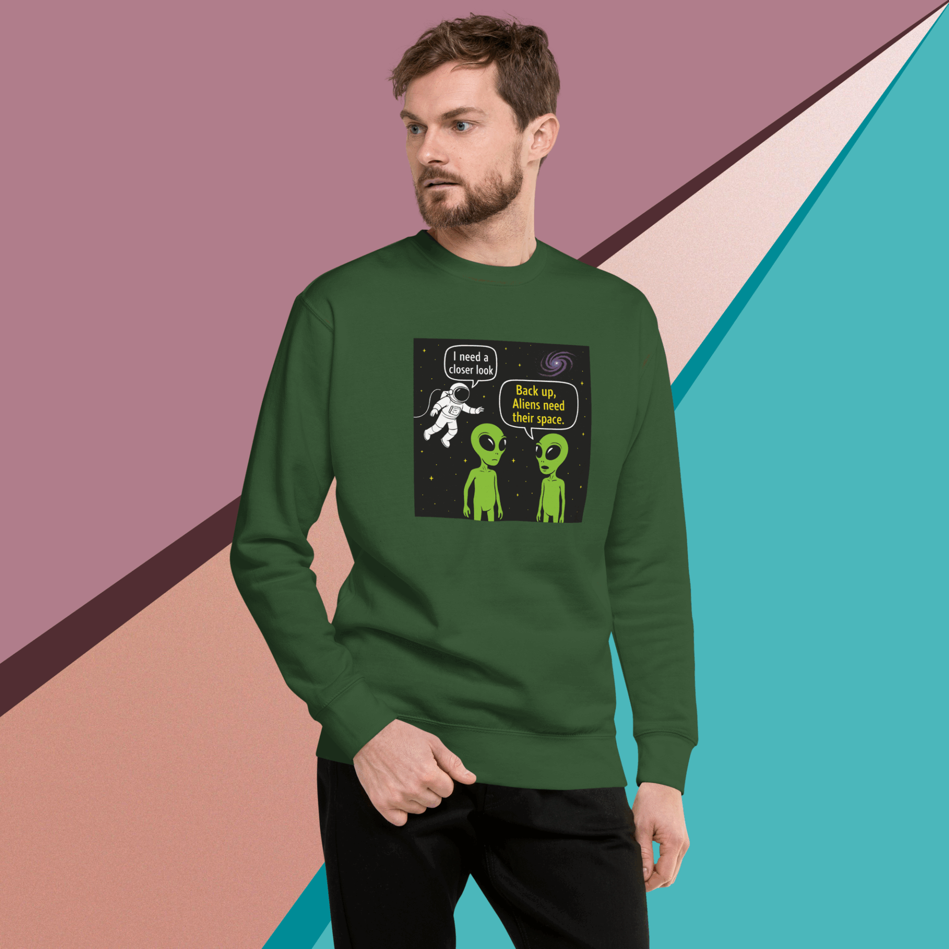 Man wearing green sweatshirt with a humorous alien abduction graphic.
