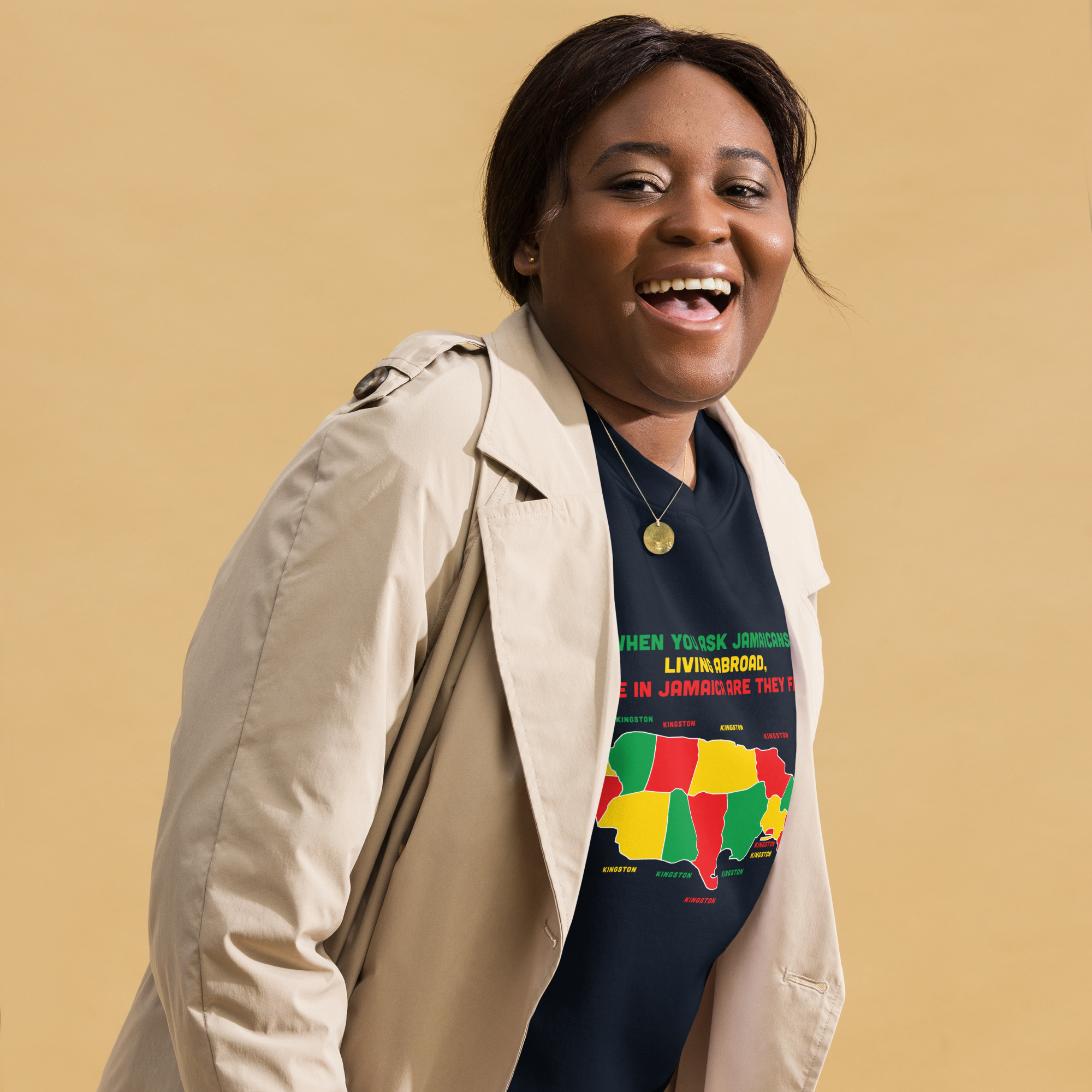 Smiling woman wearing a colorful Jamaica-themed T-shirt and beige coat.