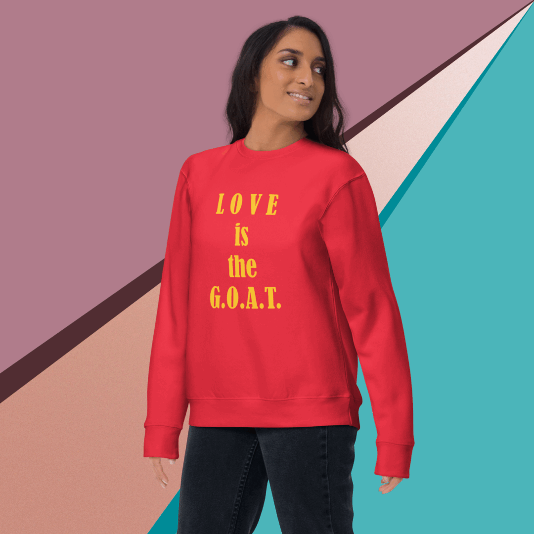 unisex-premium-sweatshirt-team-red-front-68f061abccdbe Woman wearing a red sweatshirt with "Love is the G.O.A.T." text.