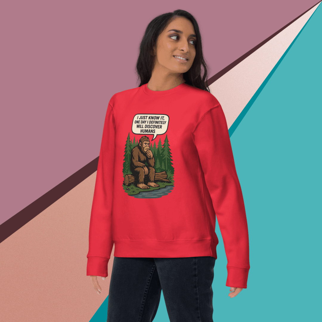 Woman wearing a red sweatshirt with a forest and animal design.