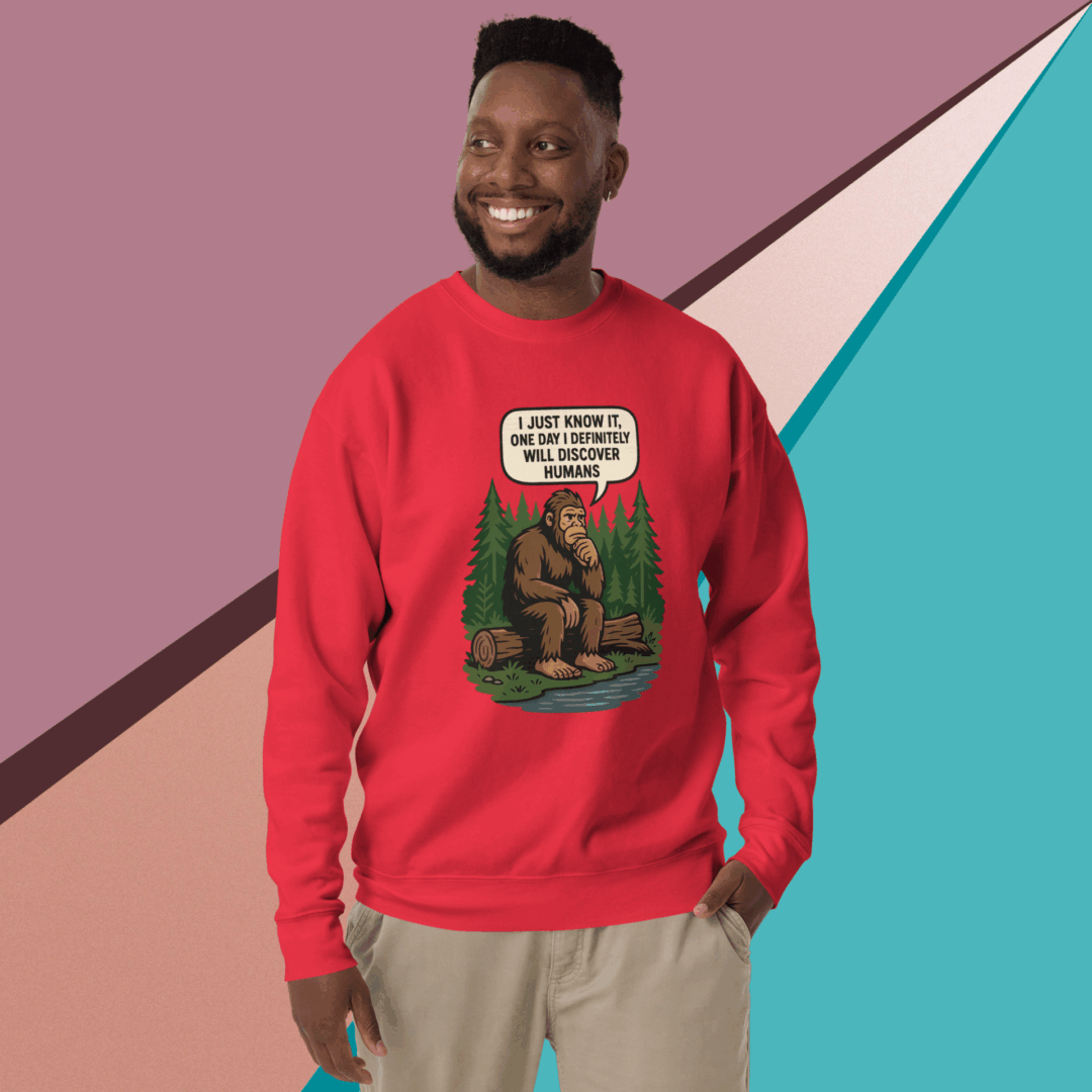 Man smiling in a red graphic sweatshirt with casual pants against a colorful geometric background.