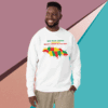 Man smiling wearing a white sweatshirt with a colorful African map design.