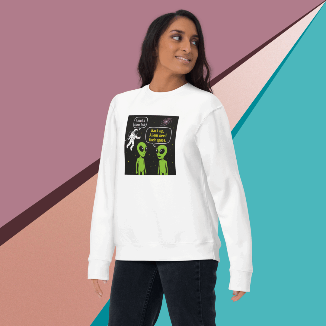 Woman wearing a white sweatshirt with a green alien design.