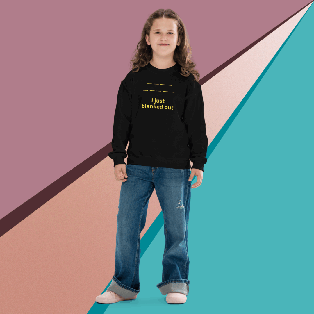 A woman in a black sweatshirt and jeans stands against a colorful geometric background.