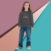 A young boy wearing a dark hoodie and jeans poses against a colorful geometric background.
