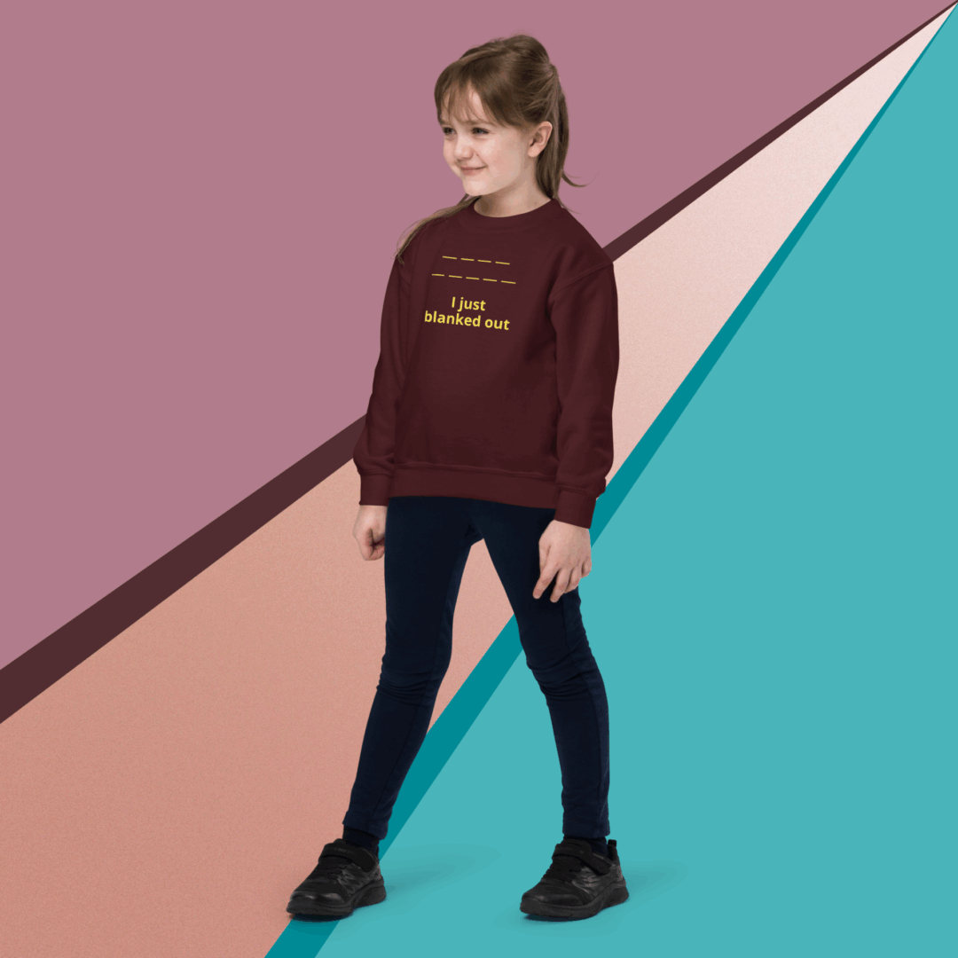 Child wearing a maroon sweater and black pants standing against a colorful geometric background.