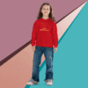 Young girl in a red sweatshirt and blue jeans stands against a colorful geometric background.