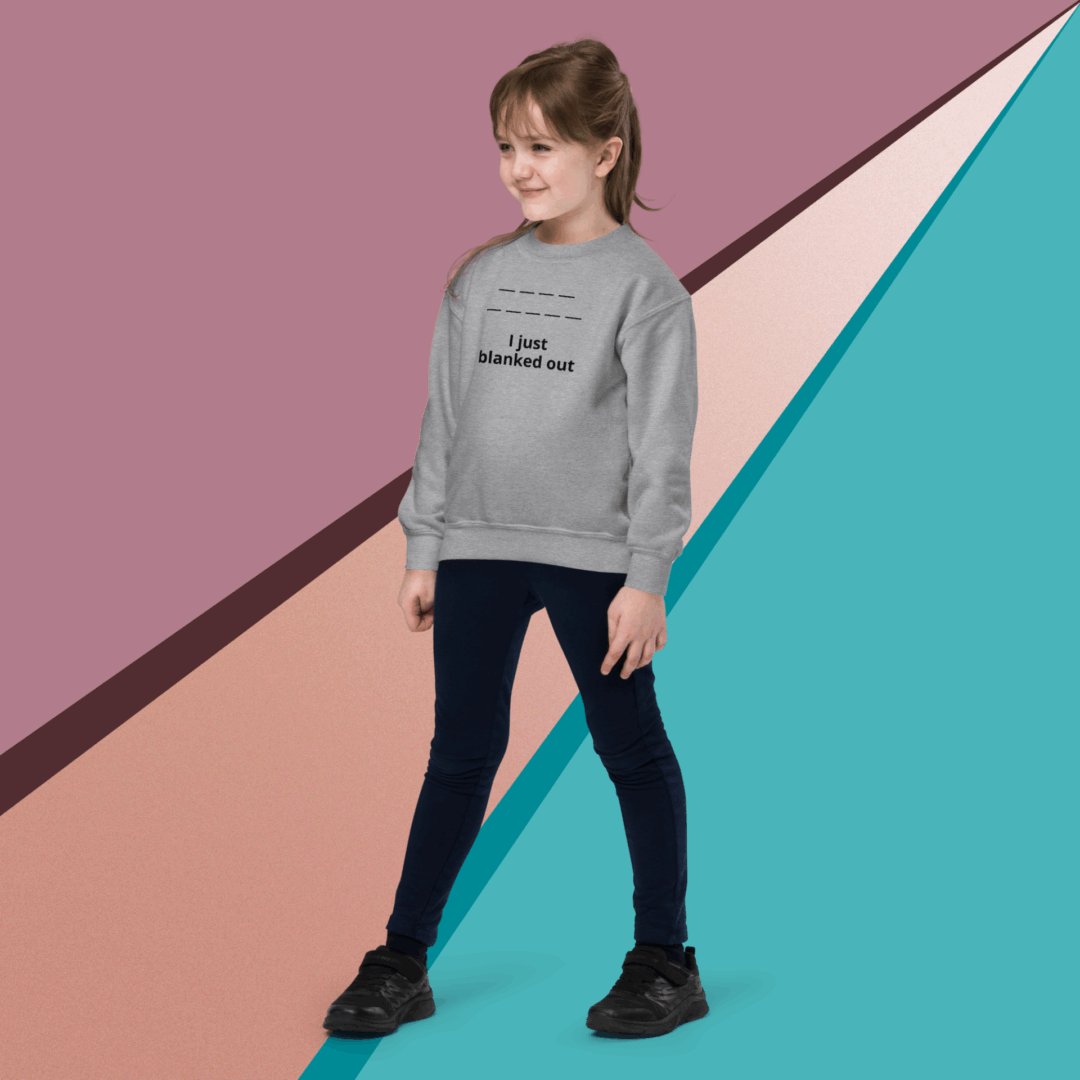 Young girl in a gray sweatshirt and black pants posing against a colorful geometric background.