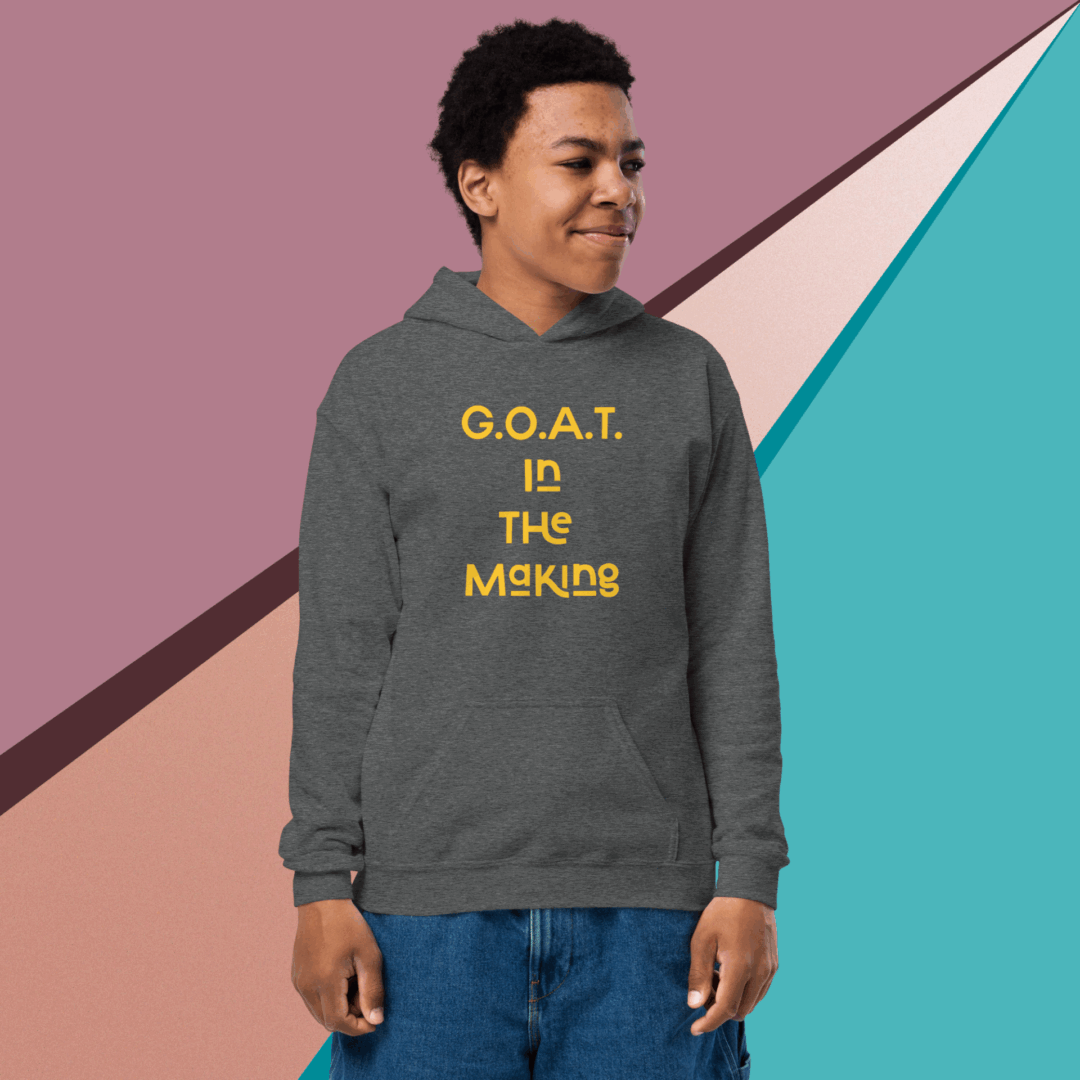A young man wearing a hoodie with the text 'G.O.A.T is the meaning.'