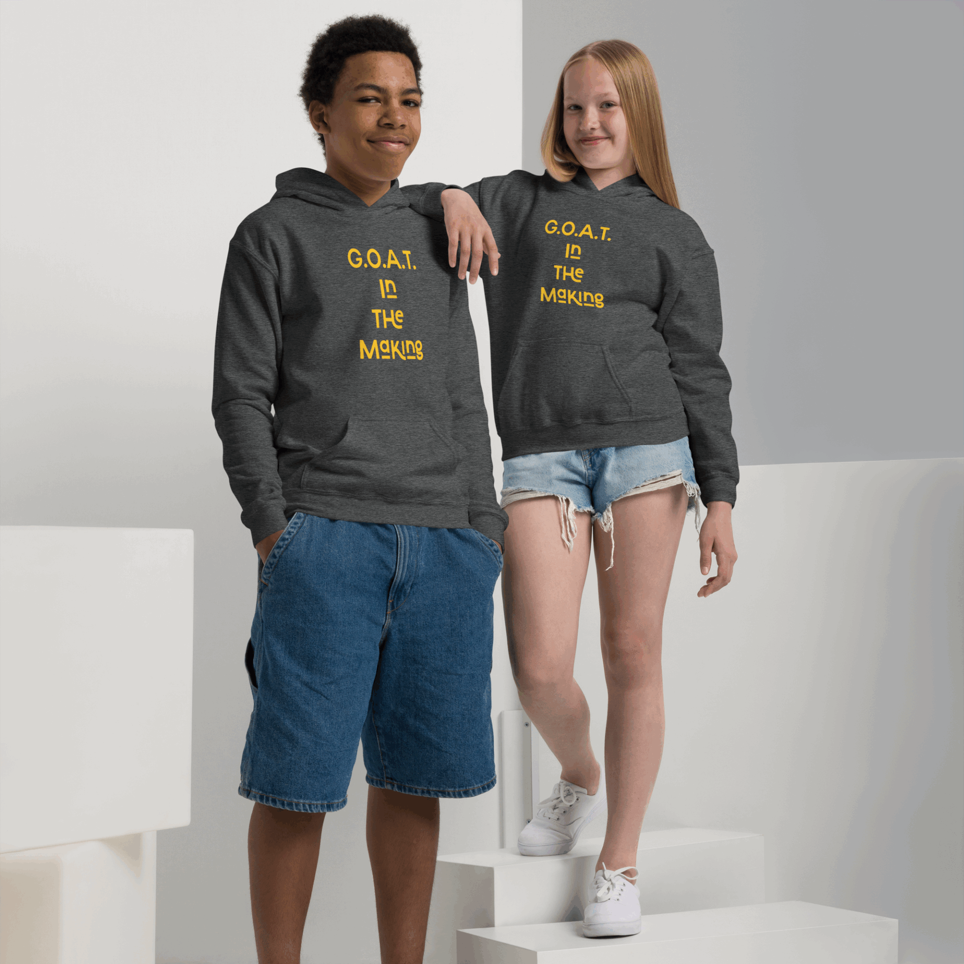 Two kids wearing matching hoodies with fun text designs.