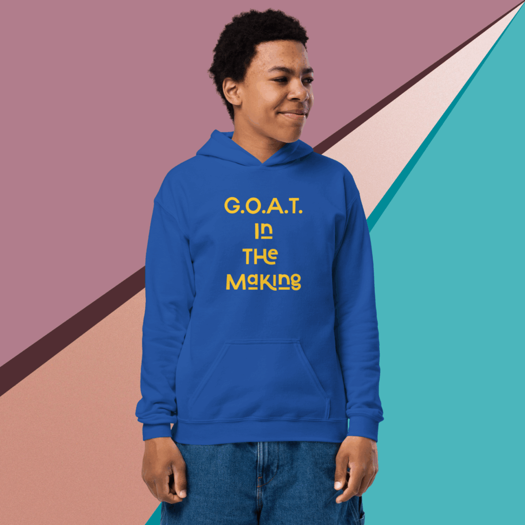 Young man wearing a blue hoodie with "G.O.A.T IS THE MISSING" text.