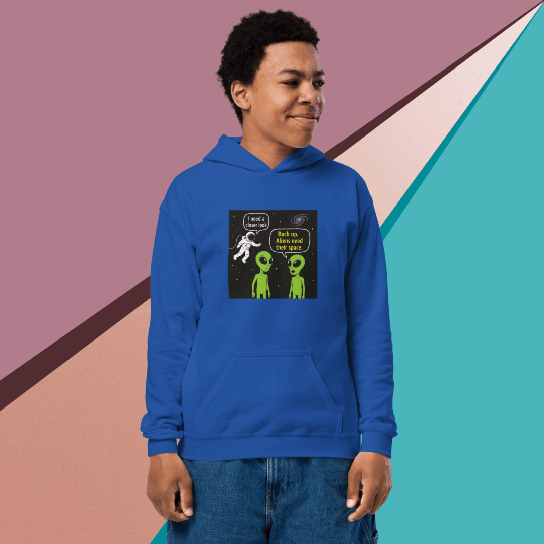 Young man wearing a blue hoodie with a graphic design, standing against a colorful geometric background.