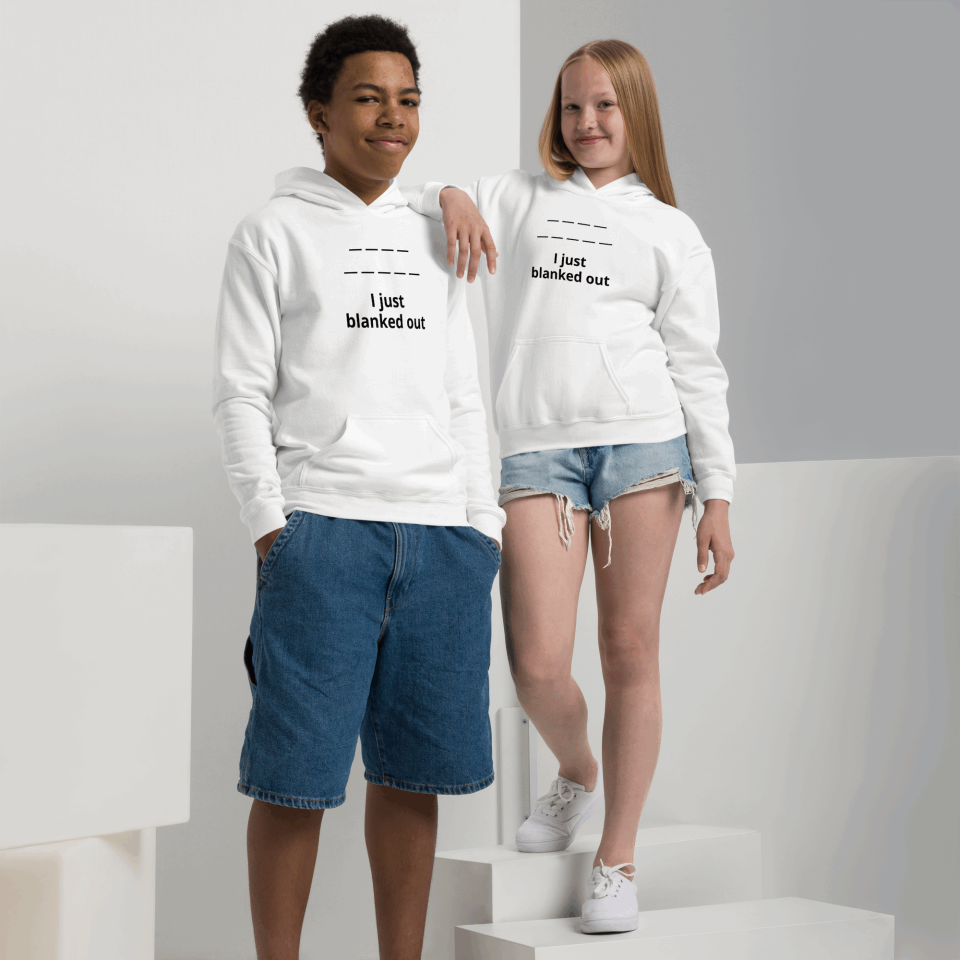 Two young people wearing matching white hoodies with text designs.